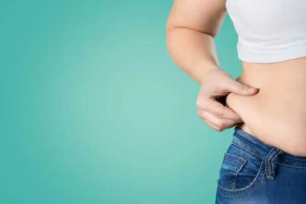 Image of woman pinching her love handles to show weight gain Northwood